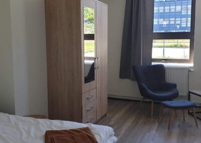 Bilde av seng, klesskap og sitteplass